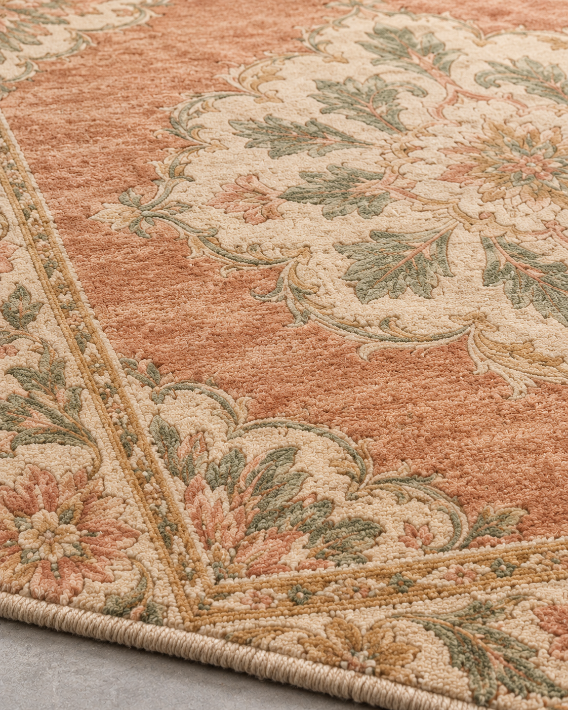 Close-up of H01 Oushak Bloom showing the ivory medallion, celadon leaves and wrapped edge in knotted wool