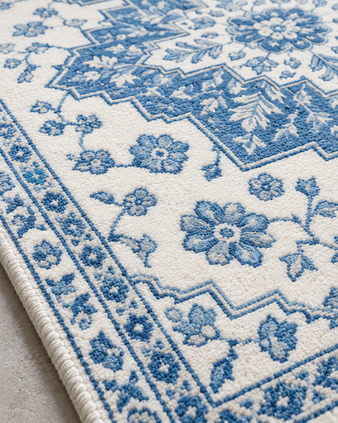 Close-up of H04 Heriz showing the stepped blue medallion edge on white in knotted wool